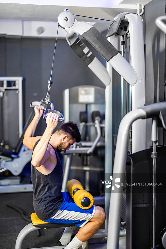年轻的男士在健身房锻炼图片素材