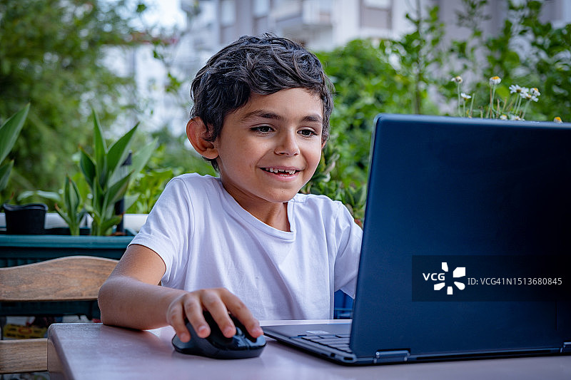 7岁男孩使用笔记本电脑图片素材