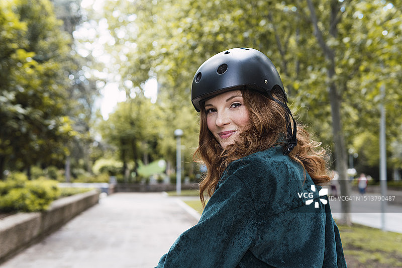 在公园里戴头盔的微笑年轻女人图片素材