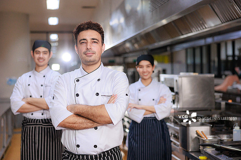 三位专业厨师一起站在厨房里图片素材