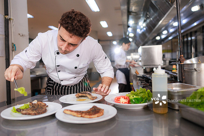摆盘的艺术：厨师用美食在厨房创作视觉杰作图片素材