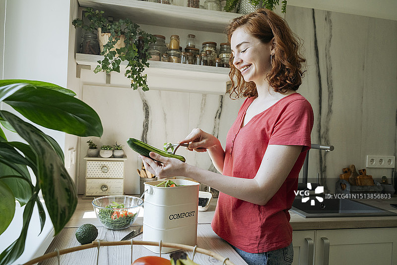 快乐的女人在家中厨房削黄瓜图片素材