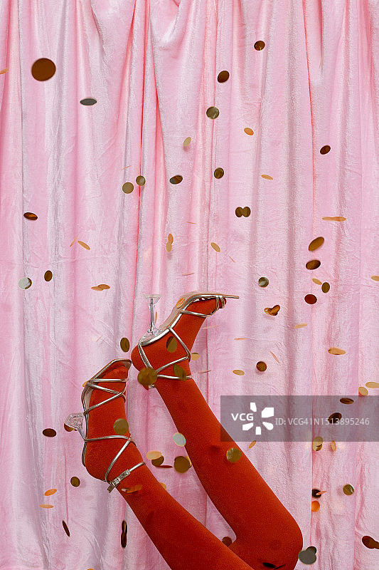 穿着凉鞋和金色纸片的双腿和脚图片素材