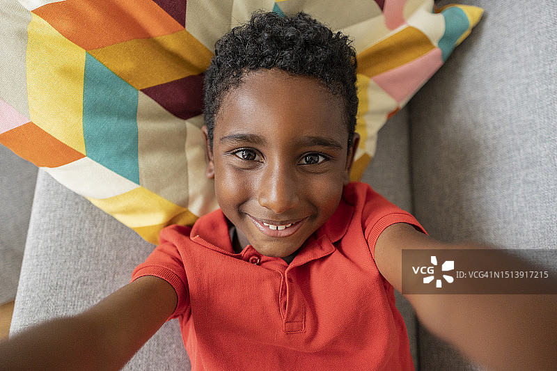 微笑男孩在家中客厅沙发上自拍图片素材