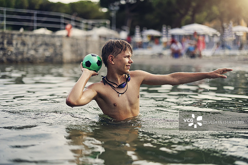 青少年男孩在城市沙滩上玩球图片素材