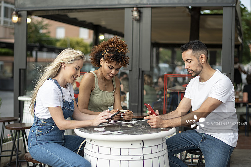 朋友们在户外露台玩手机图片素材