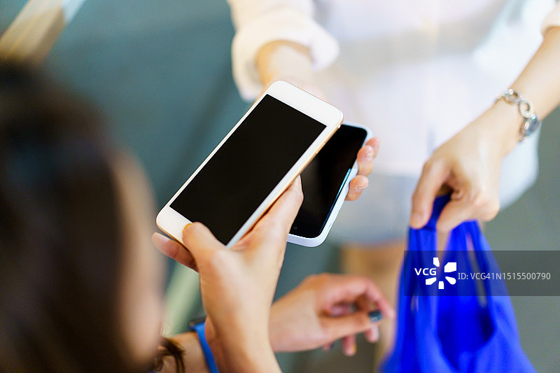 用智能设备进行数字支付的女性朋友图片素材