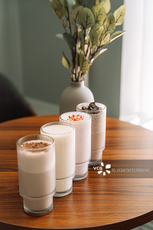 木桌上玻璃杯中不同口味的奶昔图片素材