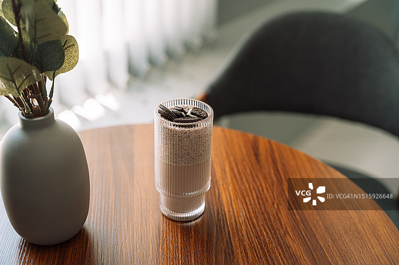 木桌上玻璃杯中搭配饼干的巧克力奶昔图片素材