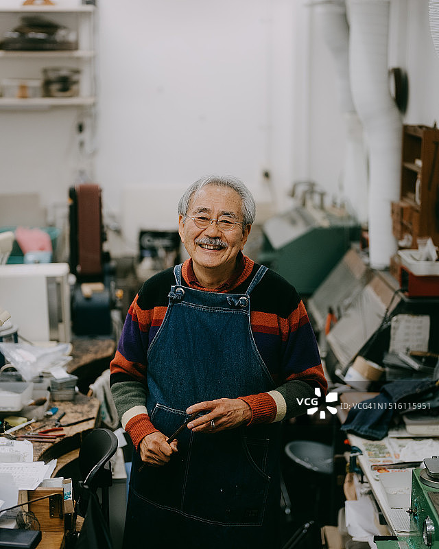 在珠宝工作室工作的老年艺术家图片素材