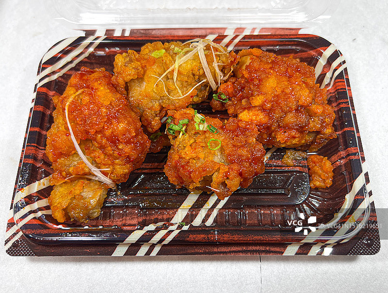 一次性塑料盒中的调味炸鸡图片素材