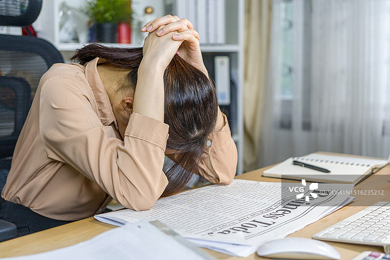 在笔记本电脑前低头的女商人图片素材