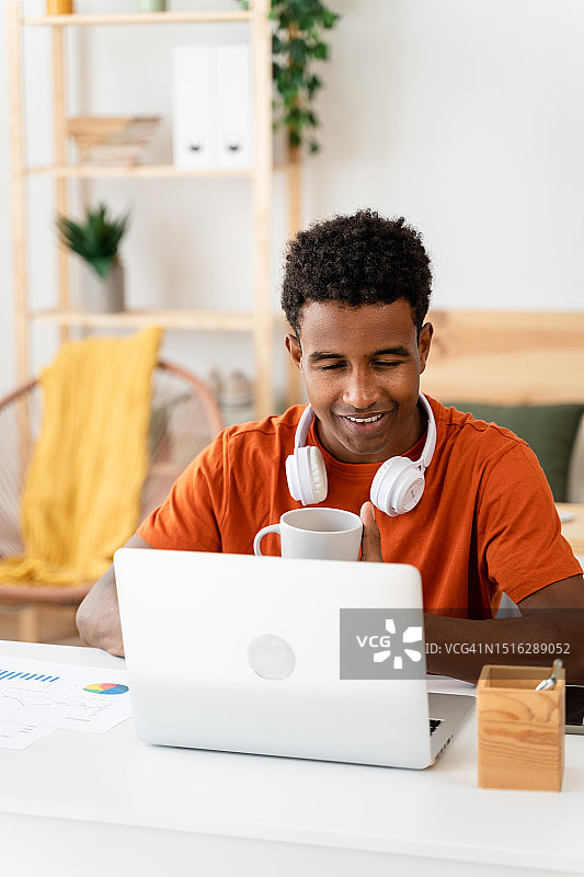 使用笔记本电脑工作的黑人男子图片素材