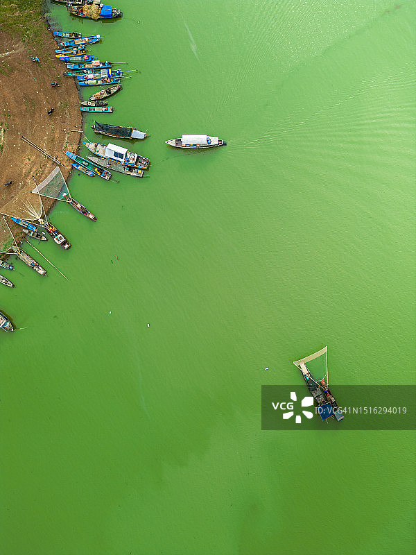 越南Tri An湖Ben Nom渔村鸟瞰，绿藻季的清新景象，传统渔船停泊图片素材