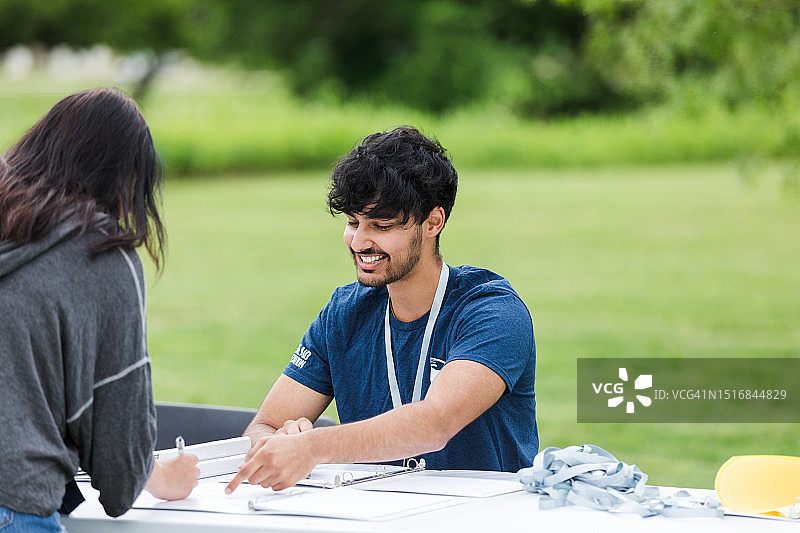 年轻男子指导女子进行登记图片素材