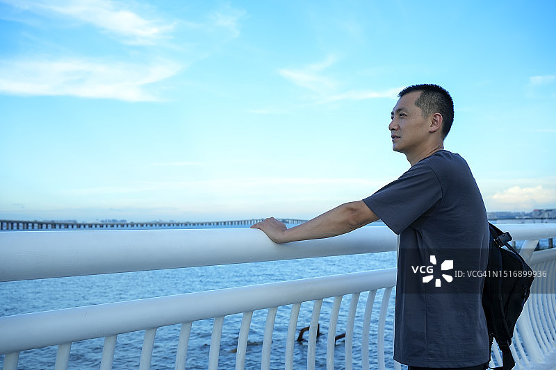 男乘客在观景台上看海图片素材