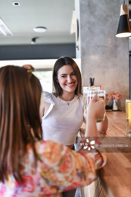 女性微笑举啤酒庆祝敬酒图片素材