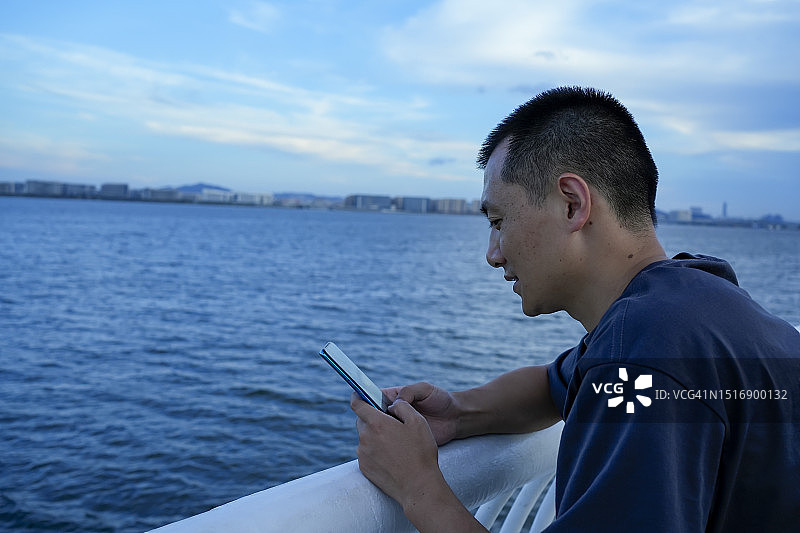 乘客在观景台上使用手机图片素材