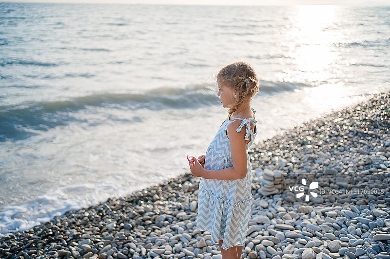 儿童在日落时看着海滩上的波浪图片素材