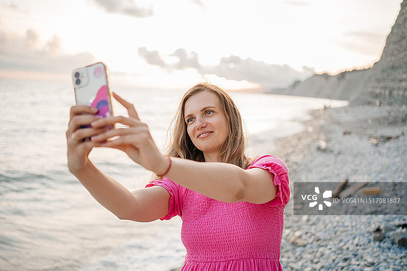 女人在海边用智能手机进行视频通话图片素材