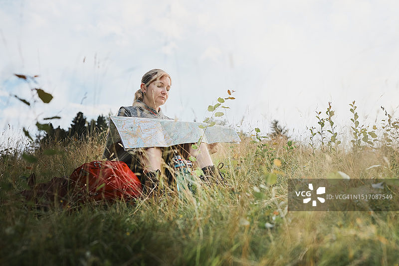 坐在田野里眺望天空的年轻女子图片素材