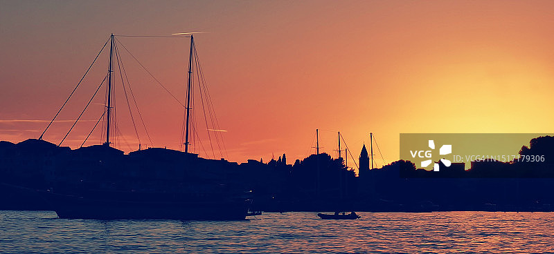 日落时分海面上帆船的剪影图片素材