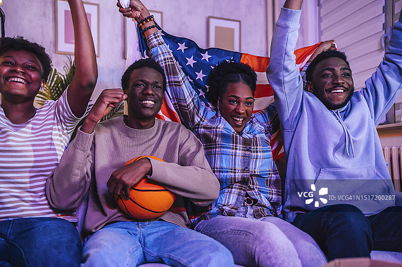兴奋的美国球迷在家观看篮球比赛图片素材