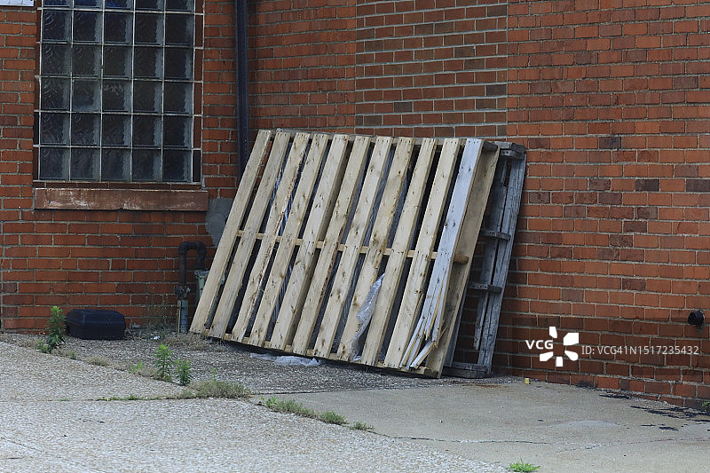 靠在砖墙上的运输托盘图片素材