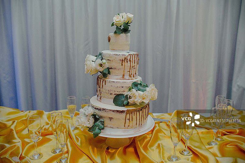 四层婚礼蛋糕、白色玫瑰与香槟图片素材