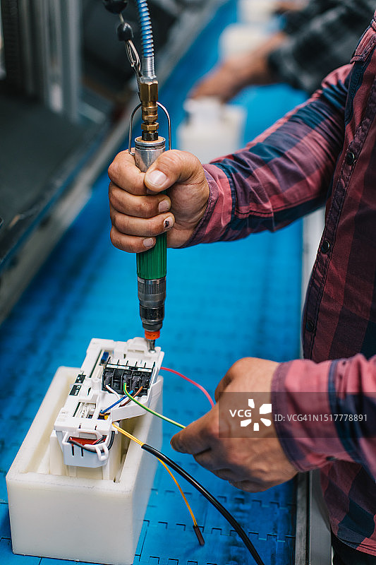 工厂里使用气动扳手的产业工人图片素材