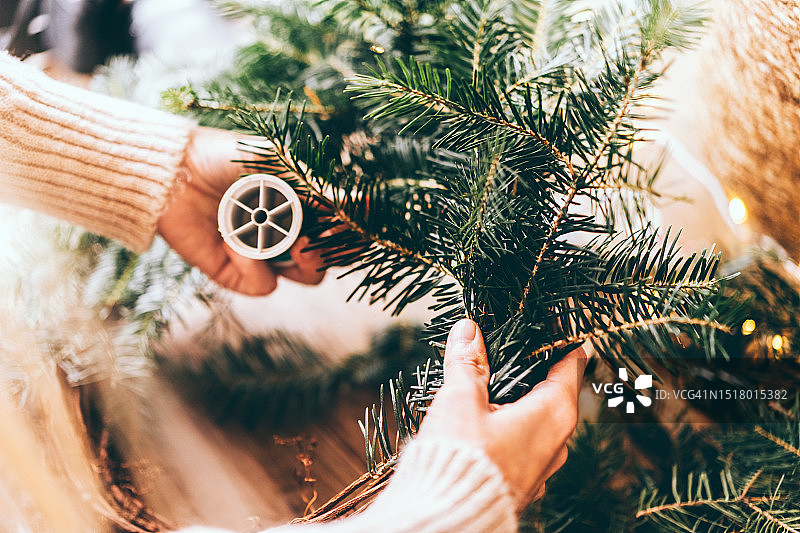 女人在木桌上制作圣诞花环图片素材