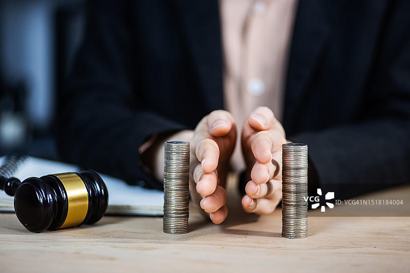 储蓄和投资概念。商人分隔硬币堆。财产分割，离婚概念图片素材