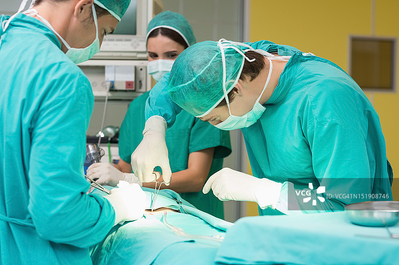 外科医生用剪刀为病人做手术图片素材
