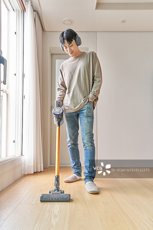 韩国青年室内扫地吸尘图片素材