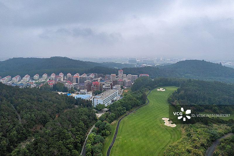 雾天高尔夫球场的建筑和草坪鸟瞰图图片素材
