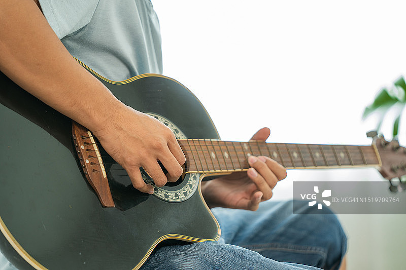 男人手弹奏原声吉他图片素材