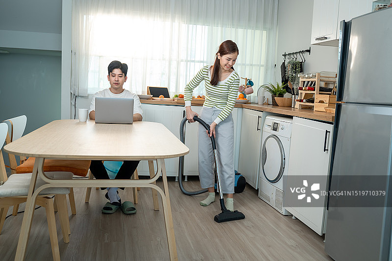年轻的亚洲夫妇一起做家务，打扫卫生图片素材