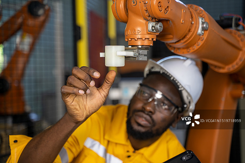 质量控制工程师使用触摸板监控机器人焊接图片素材