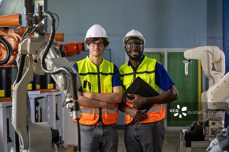 工程师在金属工厂检查和维护机器人手臂图片素材