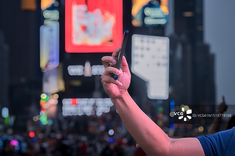 年轻男子在曼哈顿时代广场用手机自拍图片素材