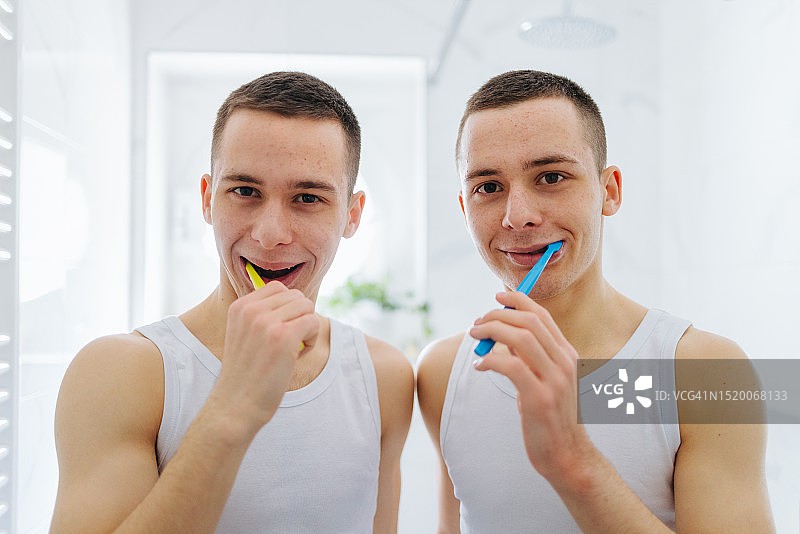 年轻的双胞胎兄弟在家刷牙图片素材