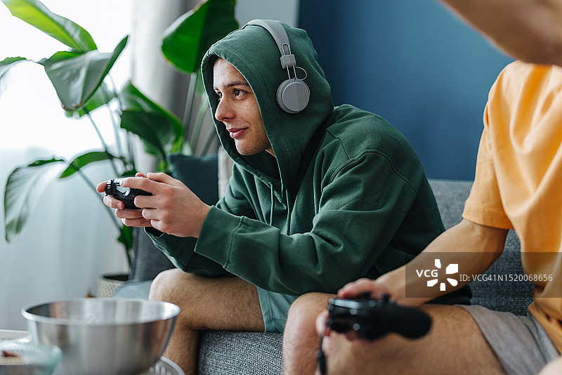 在家玩电子游戏的年轻男人们图片素材