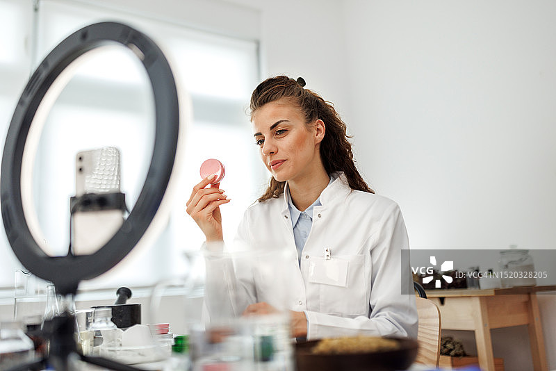 女人在她的工作室里拍摄自制护肤霜的视频图片素材