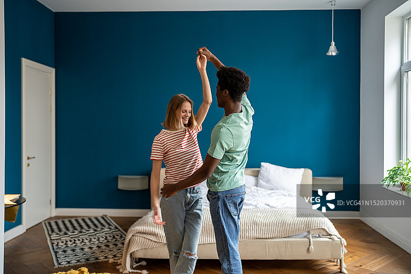 幸福情侣在卧室里跳舞，享受浪漫的家庭约会图片素材