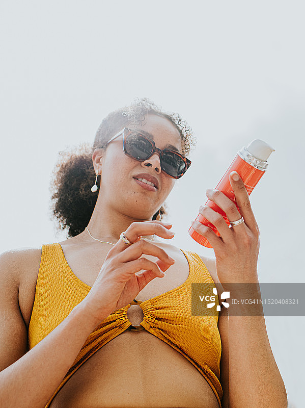 女人仔细检查她的防晒霜中的成分图片素材