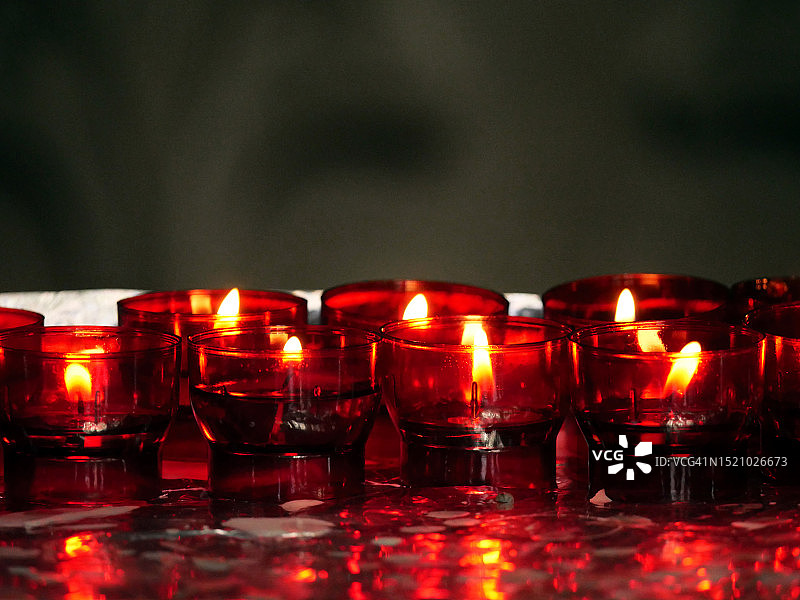 比利时布鲁塞尔教堂内点燃的红色小蜡烛图片素材