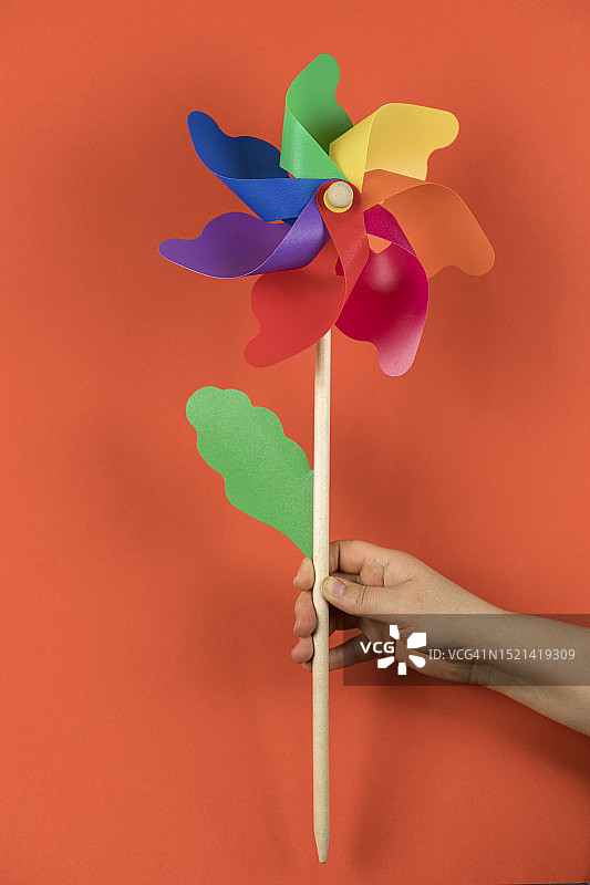 手持彩色风车，展示绿色能源概念图片素材