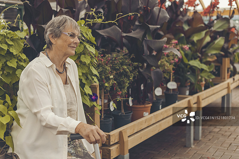 年长的女人坐在园艺中心图片素材