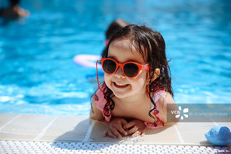 在游泳池里快乐大笑的幼儿女孩图片素材