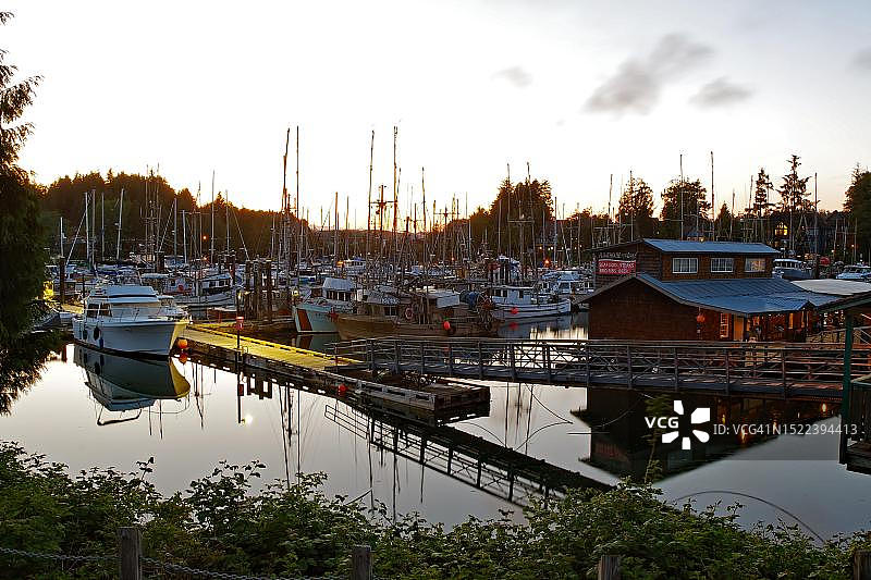 加拿大不列颠哥伦比亚省温哥华岛Ucluelet小港口的傍晚氛围，灯火通明的船屋和码头图片素材